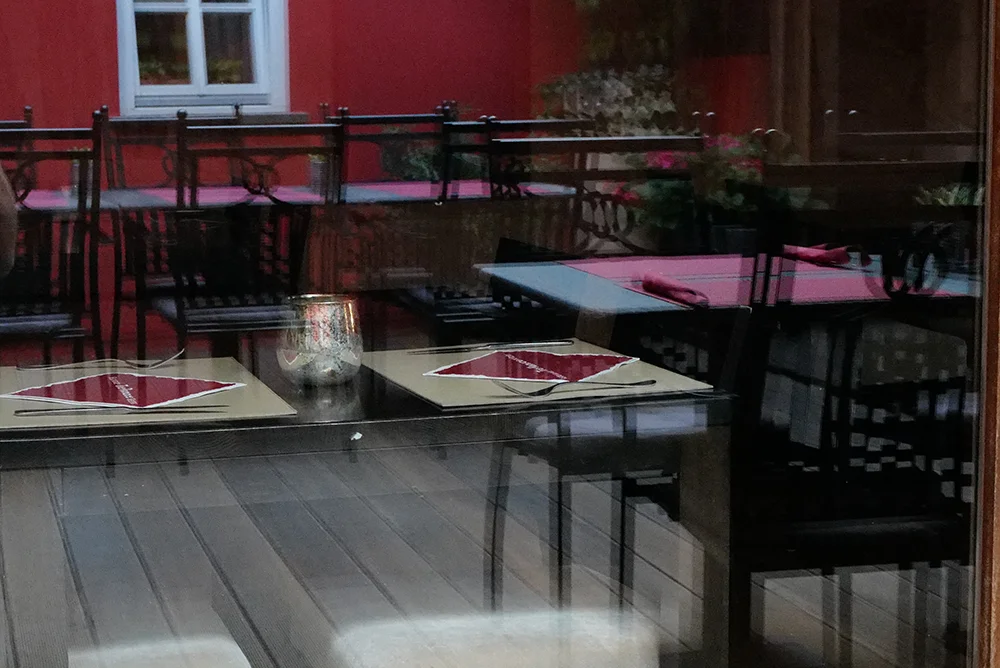 Streetfotografie mit der Leica Q3 – Spiegelungen in einem Restaurantfenster
